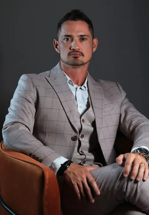 Dr. Sharbo Casagrande, de terno claro, sentado em uma poltrona de couro