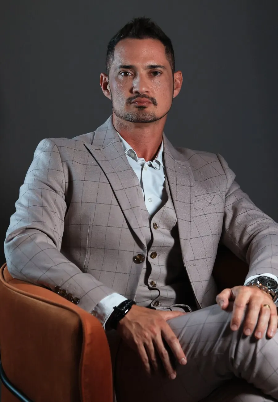 Dr. Sharbo Casagrande, de terno, sentado numa poltrona